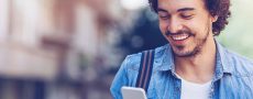 Online flirten - Frau liegt mit Smartphone auf einem Bett