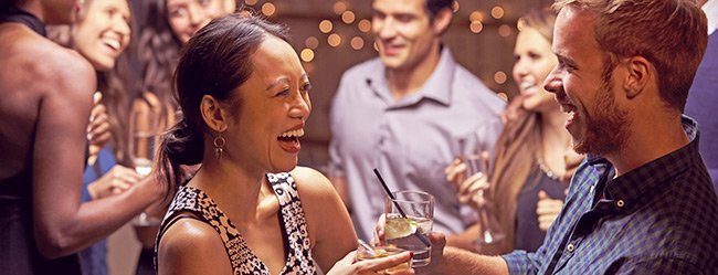 Mann und Frau lernen sich auf Party mit den richtigen Smalltalk Fragen kennen
