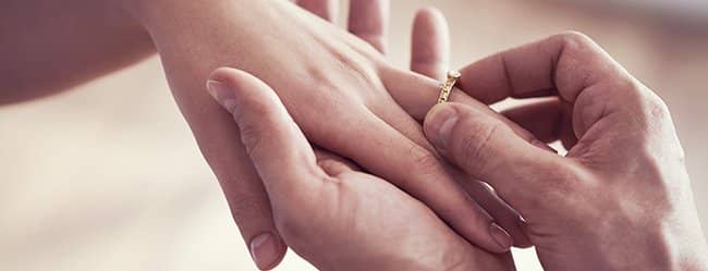 Mann steckt Frau Ring an den Finger - sie fragt sich:" Ist er der Richtige?"