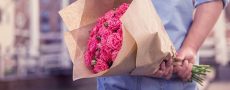 Mann mit Blumenstrauß hinter seinem Rücken als Symbolbild für das heutige Verhalten beim Date