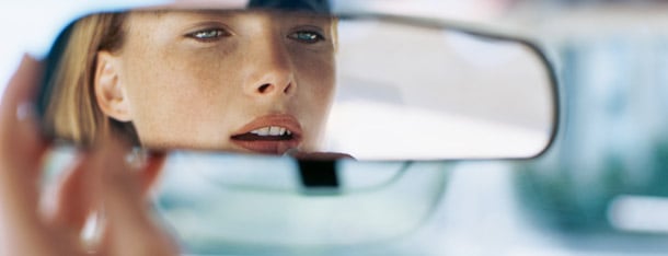 Frau trägt Lippenstift im Autospiegel auf und ist bereit fremdzuflirten