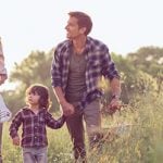 Verabredung mit Kind: Mann und Frau treffen sich mit zwei Kindern und machen Spaziergang durch die Natur