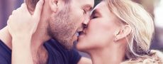 Mann mit Bart küsst Frau mit rotem Lippenstift richtig
