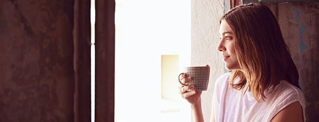 Neurotiker: Frau trinkt Kaffee und schaut aus dem Fenster