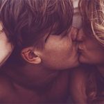 Mann und Frau unter der Bettdecke küssen sich leidenschaftlich als Symbolbild für Sexualität in der Partnerschaft