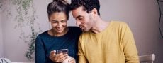 Mann schaut bei Frau aufs Handy - Symbol für Lass uns Freunde bleiben